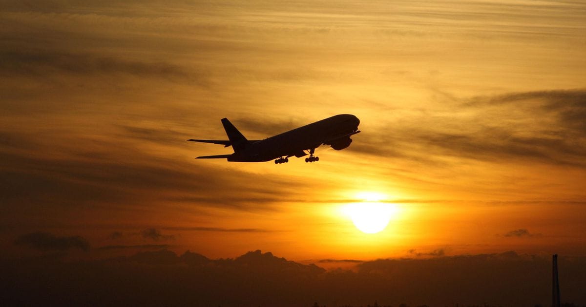 Silhouette d’un avion au décollage au coucher du soleil